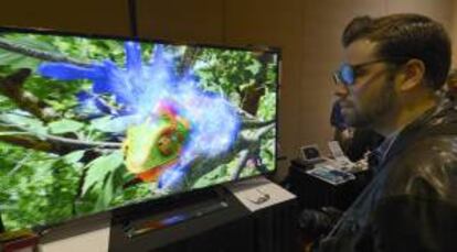 Un asistente observa un nuevo modelo de televisor 3D promocionado por LG, durante la víspera de la apertura de la feria CES, en Las Vegas (Nevada EE.UU.).