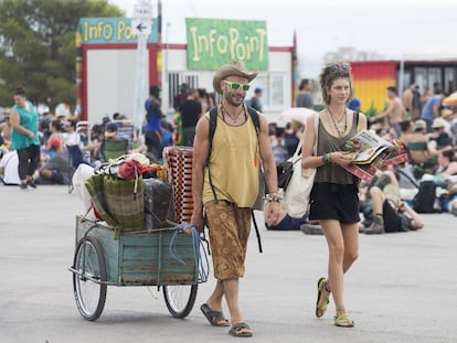 Asistentes al Rototom trasladan su equipaje en un carrito.