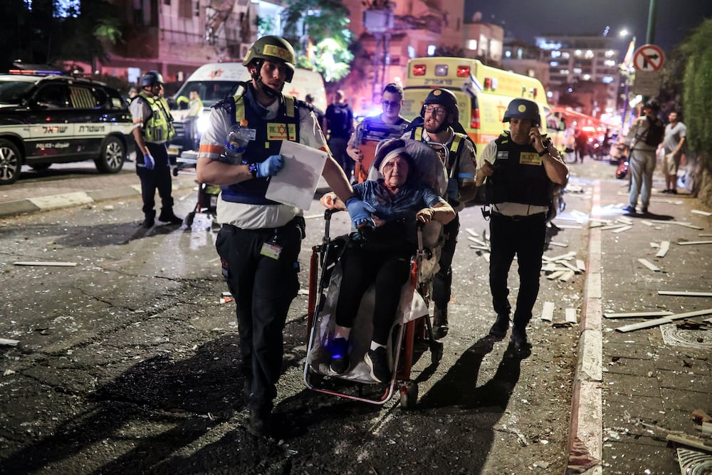 Rescue personnel evacuate a wounded woman at an impact site following missile attack from Iran on Israel, in Ramat Gan, Israel  June 13, 2025 REUTERS/Itai Ron   ISRAEL OUT. NO COMMERCIAL OR EDITORIAL SALES IN ISRAEL