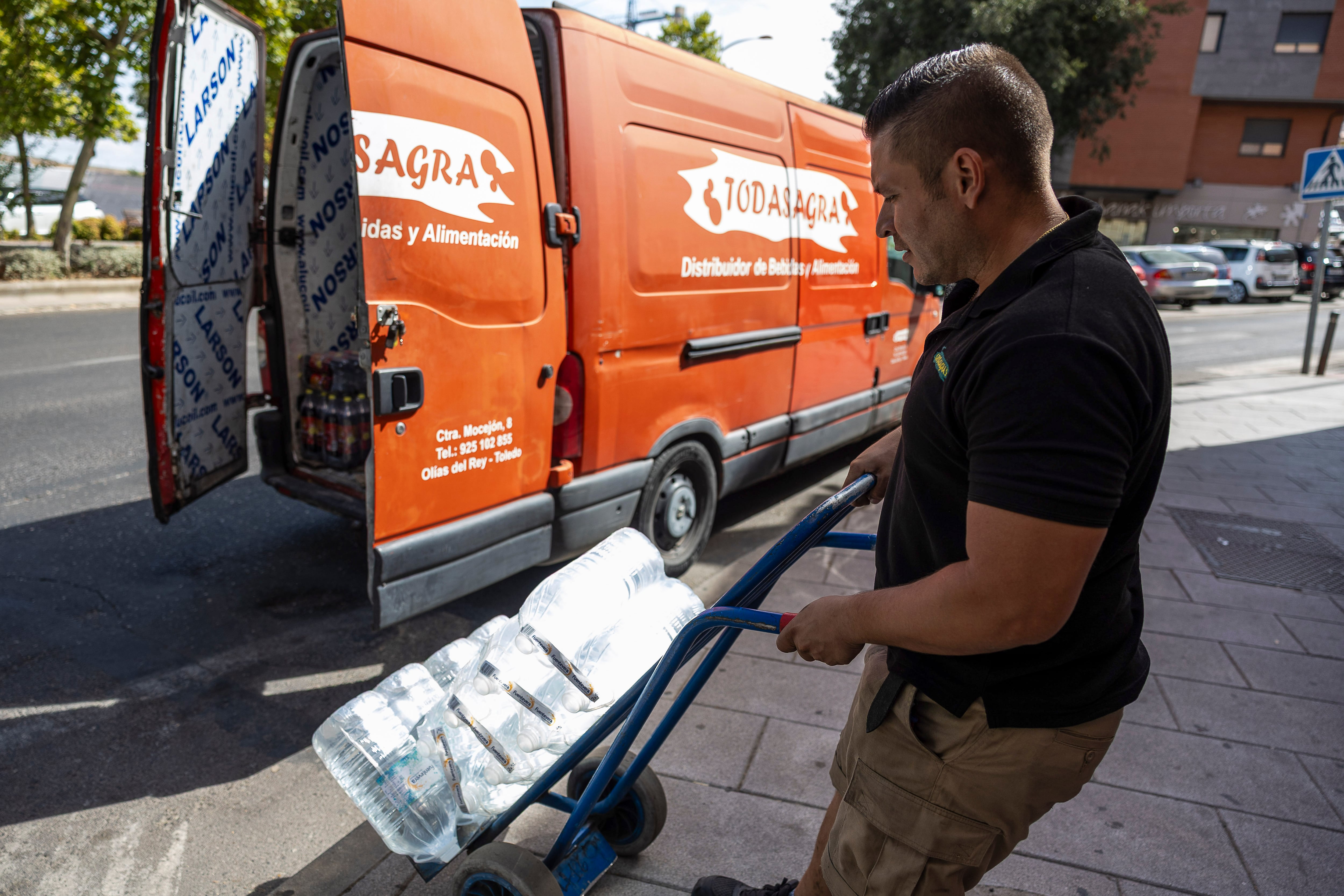 Un trabajador distribuye bebidas a un local hostelero en Toledo, este martes