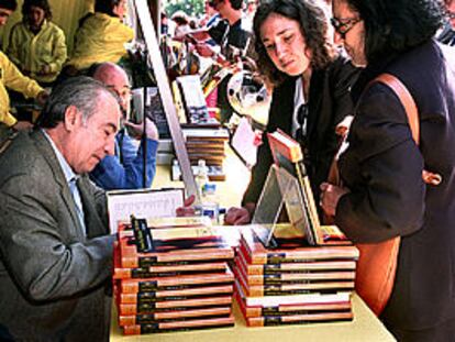 Tomás Eloy Martínez, firmando ejemplares de <b></b><i>El vuelo de la reina.</i>