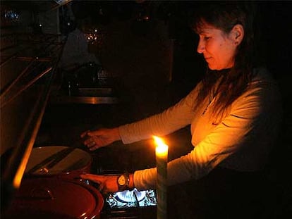 Una mujer, víctima del apagón por el temporal, cocina sin luz en un bar de Sedes, en Narón.