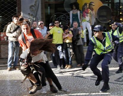 Un agente golpea a Patricia Melo, fotoperiodista de la agencia AFP, durante la carga policial en la manifestación de la capital portuguesa.