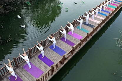 La India impulsa la práctica del yoga como una manera de combatir el impacto físico y emocional. En la imagen, clase de yoga sobre un puente en el parque de Handan, en la provincia china Hebei, el pasado lunes.