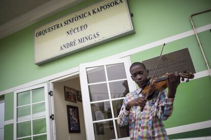 Uno de los estudiantes de la escuela de música Kaposoka practica con su violín durante los descansos entre clases a las puertas del centro situado en el barrio de Samba, en Luanda (Angola).