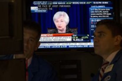 Operadores en la Bolsa de Nueva York escuchan el discurso de Yellen.