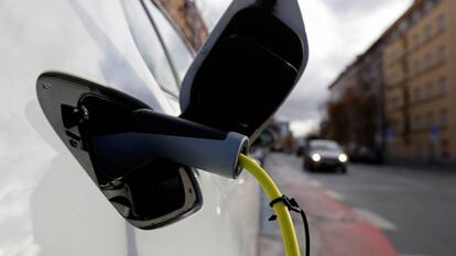 Un coche eléctrico cargando en un punto de recarga público. 