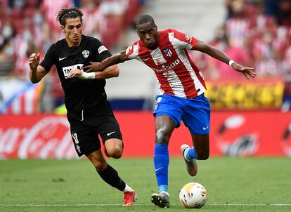 El centrocampista del atlético Geoffrey Kondogbia, mantiene el balón frente a Pere Milla del Elche durante la segunda jornada de La Liga.