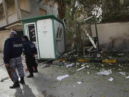 Dos polic&iacute;as junto al lugar donde explotaron los artefactos en la puerta de la residencia del embajador iran&iacute; en Tr&iacute;poli. 