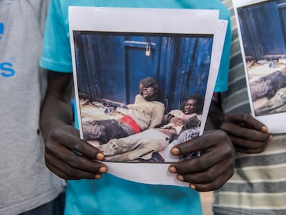 Un hombre sostiene imágenes de la violencia que sufrieron otros migrantes como él a su llegada a la frontera entre España y Marruecos, durante una manifestación en Melilla en julio de 2022.