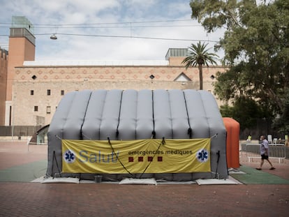 Un vecino entra en la carpa del SEM en el Raval.