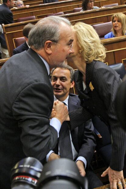Pedro Solbes y Elena Salgado se saludan ante Zapatero, en mayo de 2009, en el Congreso.