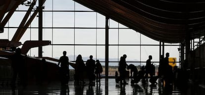 Varias personas atraviesan la T4 del Aeropuerto Madrid Barajas.