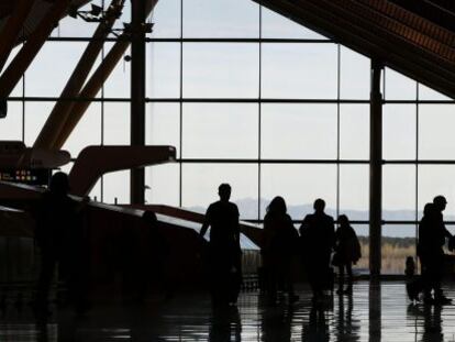 Varias personas atraviesan la T4 del Aeropuerto Madrid Barajas.