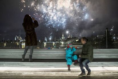 Un niño se tapa los oídos durante los fuegos artificiales durante la celebración del Año Nuevo en la ciudad de Moscú (Rusia).