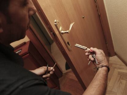 Un cerrajero cambia la cerradura de una puerta en un piso asaltado este fin de semana.