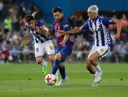 Messi (centro) es flanqueado por dos jugadores del Alavés.