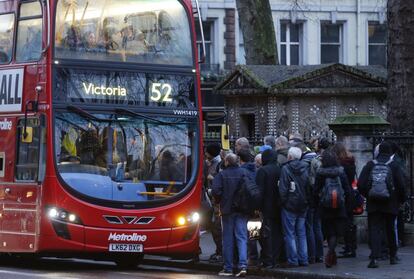 Personas esperan subir a un autobús en el exterior de la estación de metro de Victoria en Londres.