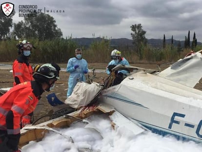 Varios bomberos junto a la avioneta accidentada en Vélez-Málaga.