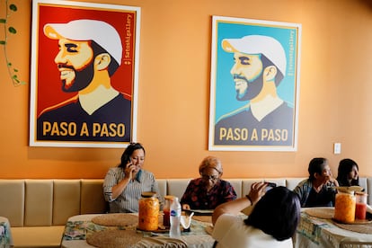 Clientes en un café de San Salvador con pósters de Nayib Bukele este 1 de agosto.