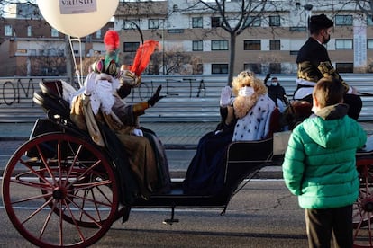 Los Reyes Magos saludan a unos niños durante el recorrido que han realizado en una calesa por las calles de Valladolid, ciudad en la que la Junta de Castilla y León ha prohibido las celebración de la tradicional cabalgata debido al aumento en los casos de covid-19.