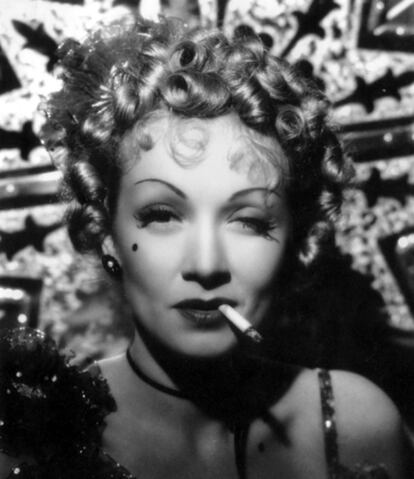 La musa del director alemán Josef von Sternberg e imagen universal de 'femme fatale' en una escena de la película 'Forja de corazones' (1942), de Lewis Seiler. El cigarrillo pegado a sus labios o enfrascado en una pitillera eran parte indivisible de sus personajes.