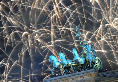 La escultura de la Puerta de Brandenburgo (Berlín) coronada por un manto de fuegos artificiales.