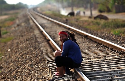 Dos niñas conversan sentadas en las vías del tren en el poblado de Guayacanes.