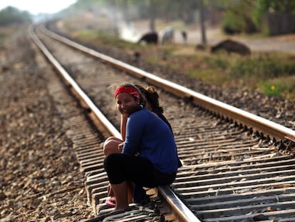Dos niñas conversan sentadas en las vías del tren en el poblado de Guayacanes.