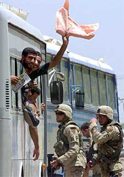 Presos iraquíes saludan desde un autobús al salir de la cárcel de Abu Ghraib.