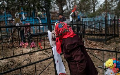 Una mujer besa el retrato de una mujer en el cementerio de Orevichi, en la zona de exclusión de Chernóbil, durante una conmemoración de la Iglesia rusa Ortodoxa por los fallecidos por la explosión del reactor nuclear de la central de Chernóbil.