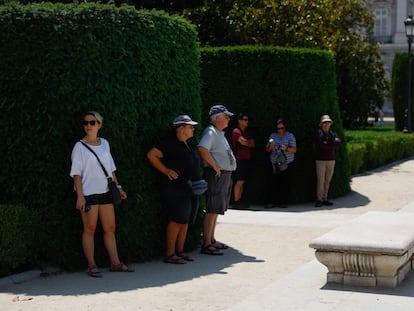 Grupos de personas descansan a la sombra este jueves, durante una jornada muy calurosa en Madrid.
