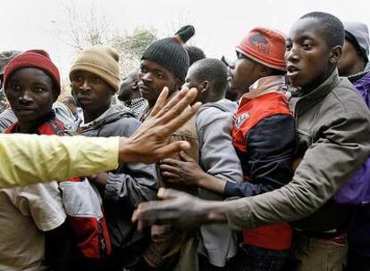Inmigrantes desplazados de sus casas aguardan el reparto de ropa de una ONG en el suburbio de Reiger Park, cerca de Johanesburgo.