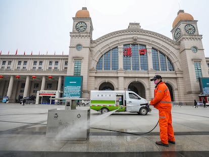 Funcionário desinfeta praça em frente à estação de trem de Hankou, em Wuhan (China).