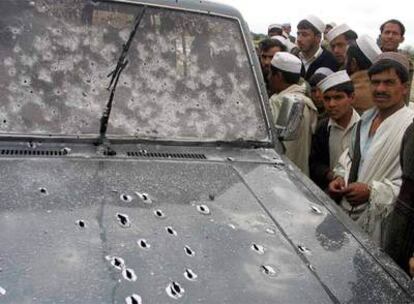 Afganos rodean un coche acribillado a balazos
