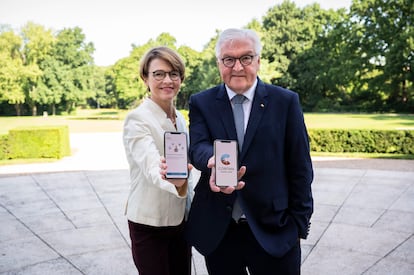 El presidente de Alemania, Frank-Walter Steinmeier, junto a su mujer, Elke Buedenbender, posan con sus móviles con la nueva app alemana de rastreo de contagios, Corona Warn, en las pantallas.