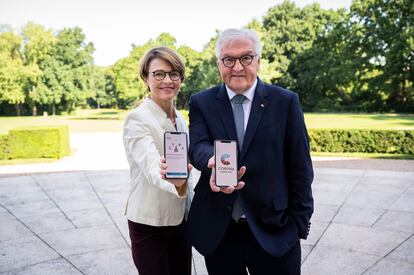 El presidente de Alemania, Frank-Walter Steinmeier, junto a su mujer, Elke Buedenbender, posan con sus móviles con la nueva app alemana de rastreo de contagios, Corona Warn, en las pantallas.