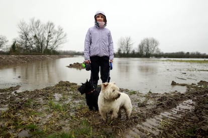 Angela Greenway de 40 años, posa frente a su casa con sus dos perros. Sus mascotas son lo primero que salvaría de su hogar.