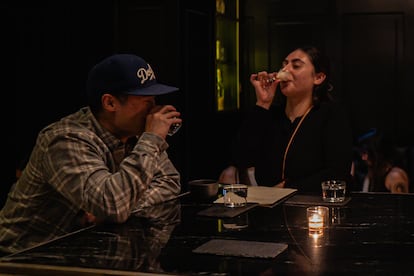 Two customers drink their cocktails on the first floor of the establishment.