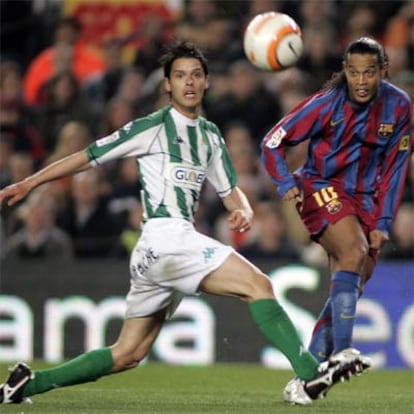 Ronaldinho disputa un balón ante un jugador del Betis