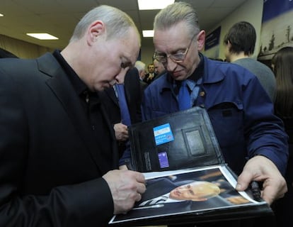 El presidente ruso, Vladimir Putin, firma un aut&oacute;grafo.