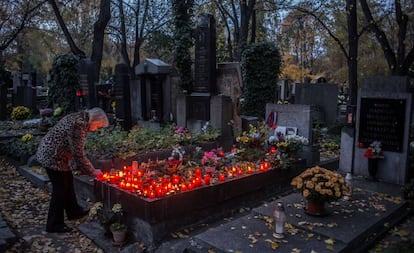 Una mujer enciende velas en el cementerio Olsany de Praga, en el día de Todos los Santos (1 de noviembre).