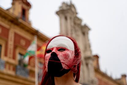 Una manifestante cubierta con una máscara, durante la concentración en Sevilla.