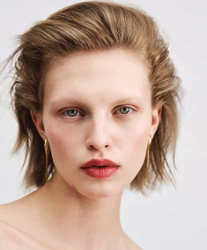 Los tonos se armonizan utilizando en boca y ojos (a suaves toques con los dedos) el bálsamo labial con color Rose Perfecto Shine Serum Lipstick (tono Coral Red, 304) de GIVENCHY BEAUTY. Pendientes de GIVENCHY por SARAH BURTON.