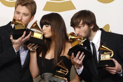 Los miembros de Lady Antebellum besan sus trofeos en una ceremonia de los Grammy.