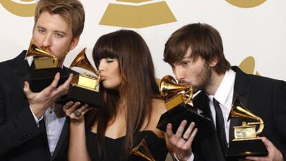 Los miembros de Lady Antebellum besan sus trofeos en una ceremonia de los Grammy.