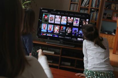 Una familia elige una película en Movistar + en su hogar.