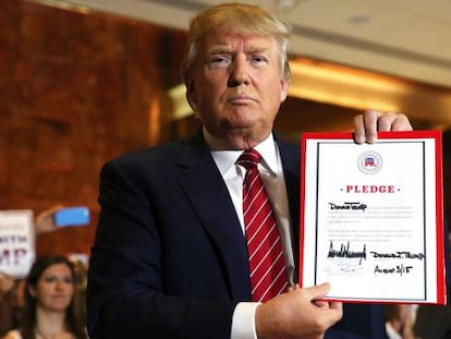 Trump con el documento de compromiso firmado.