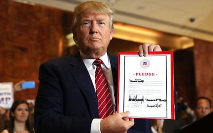 Trump con el documento de compromiso firmado.