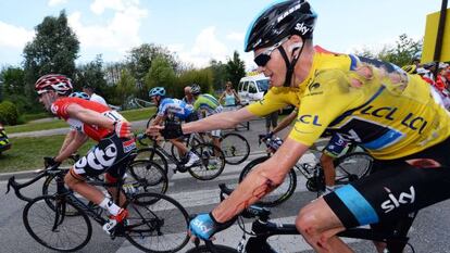 El británico Chris Froome tiende la mano al belga Jurgen Van den Broeck, tras su caída de este viernes.